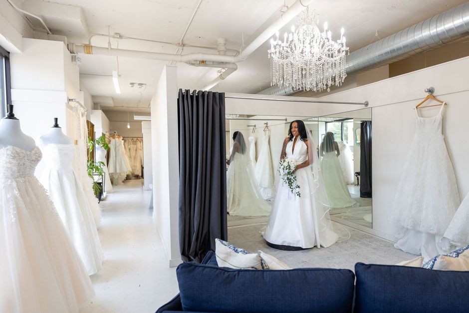 A room filled with lots of white dresses and a couch.