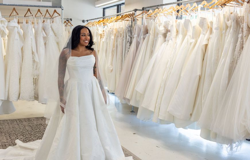 A room filled with lots of white dresses and a couch.