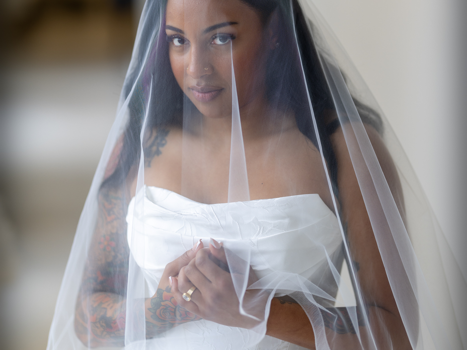 A wedding dress is hanging on a mannequin in a dressing room.