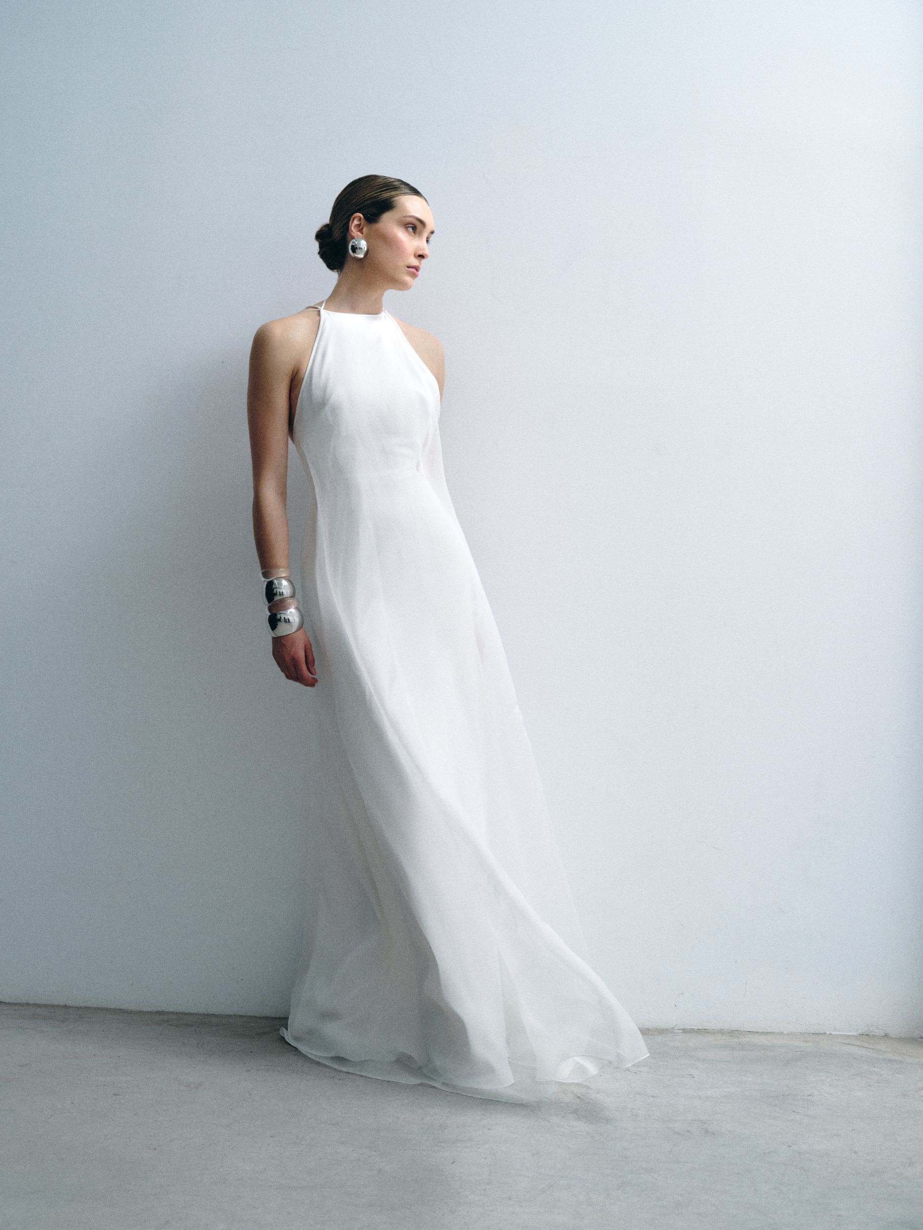A woman in a white wedding dress is holding a bouquet of flowers.