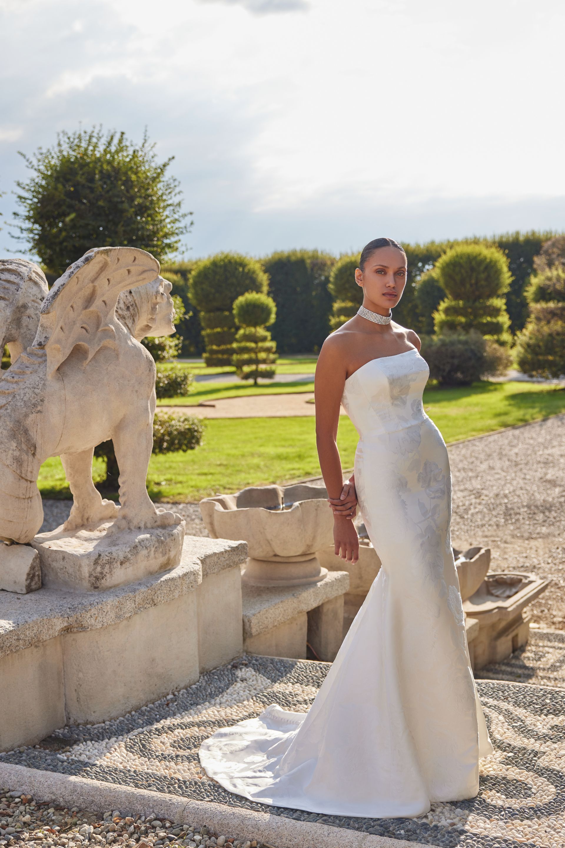 A woman is wearing a white strapless wedding dress.