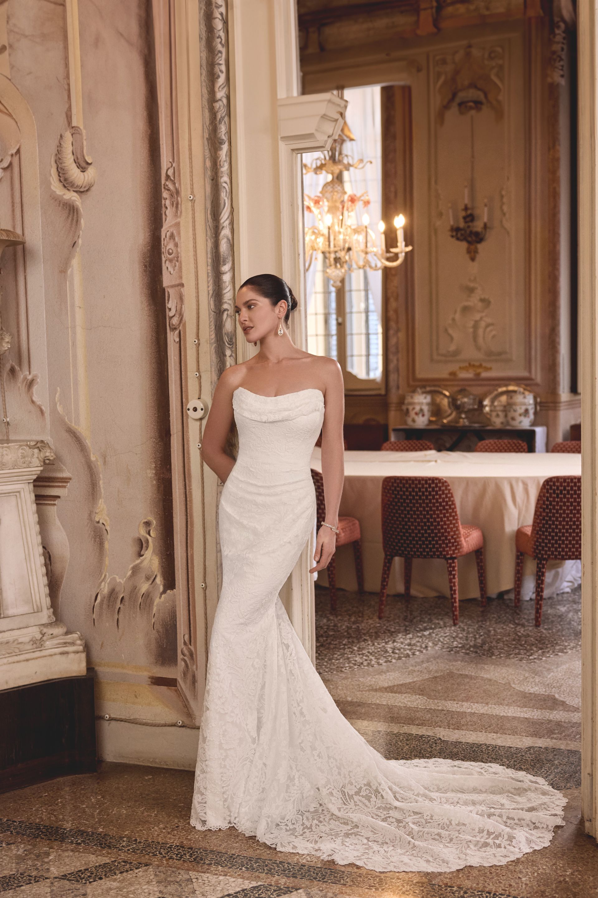 A woman is wearing a white strapless wedding dress.