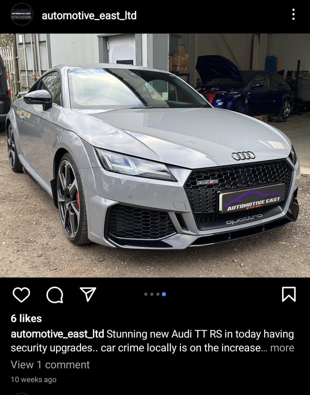A grey audi tt rs is parked in a garage.