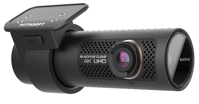 A black 4k uhd dash cam is sitting on a white surface.