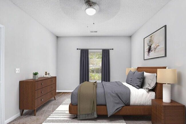 Bedroom with brown furniture, gray walls, window with dark curtains, bed with gray bedding.