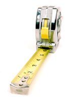 Tape measure with yellow blade extended, showing measurement markings against a white background.