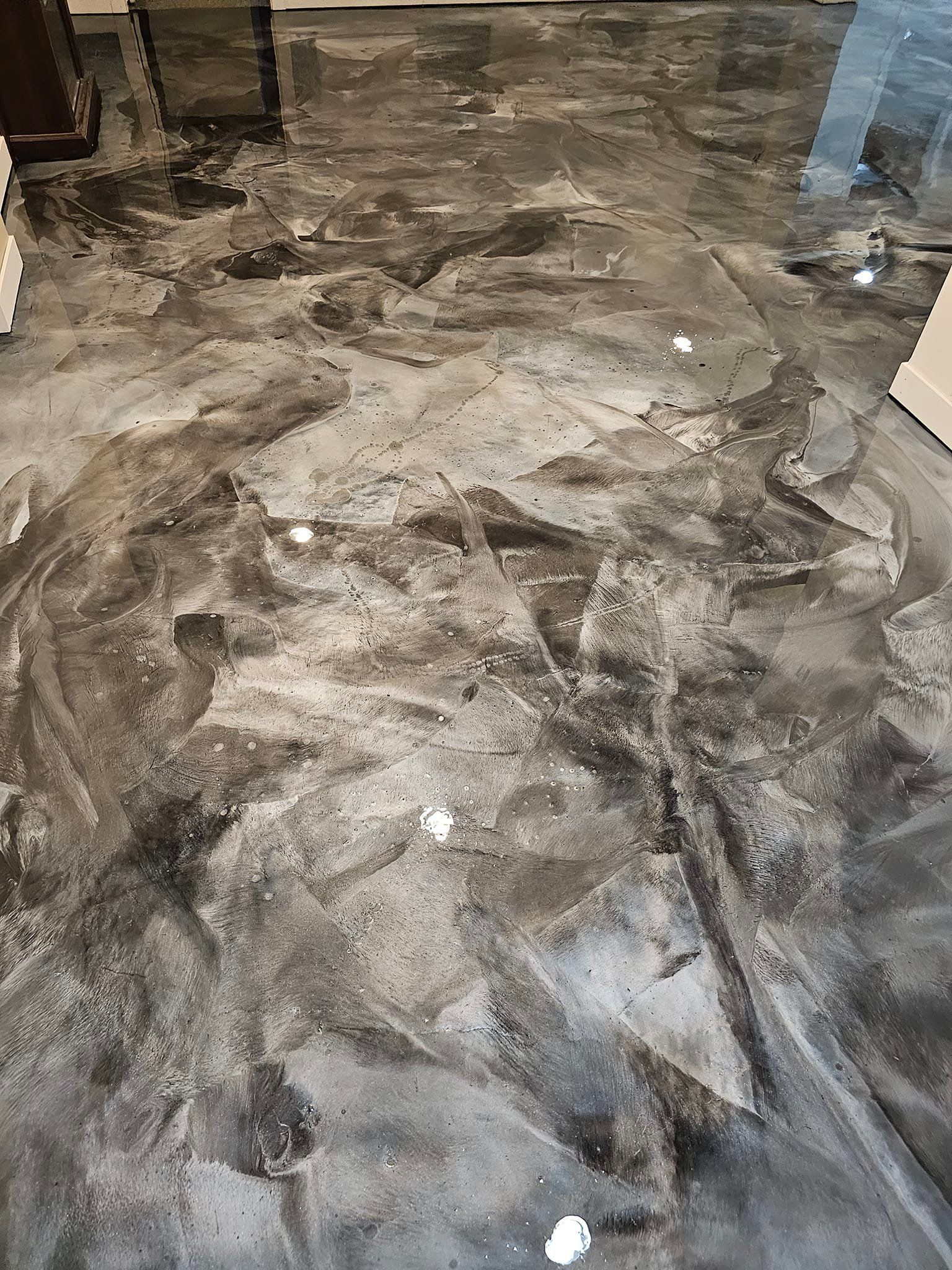 Grey and silver metallic epoxy flooring with swirled patterns; indoor setting.