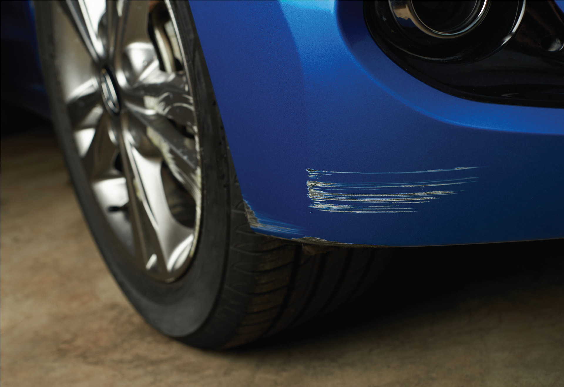 A close up of a car with a scratch on the front bumper