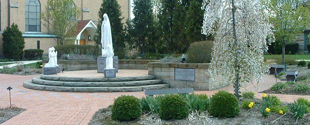 Brick pathway with steps to platform with statue