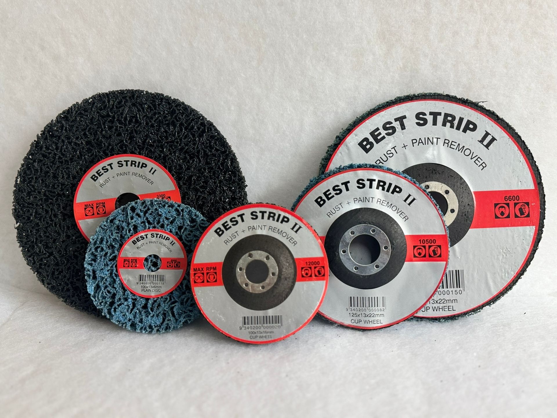 A bunch of different types of polishing pads are sitting on top of each other on a table.