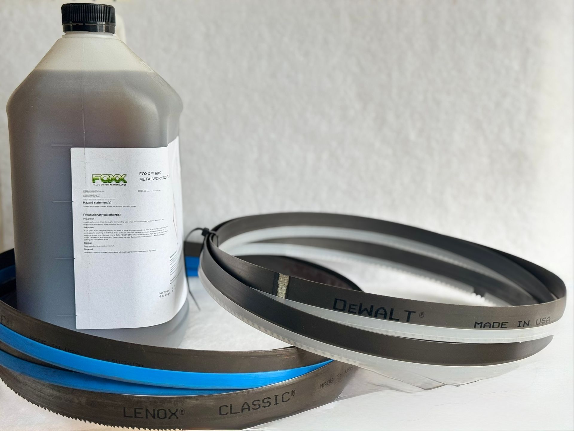 A pair of saw blades sitting on top of each other on a blue surface.