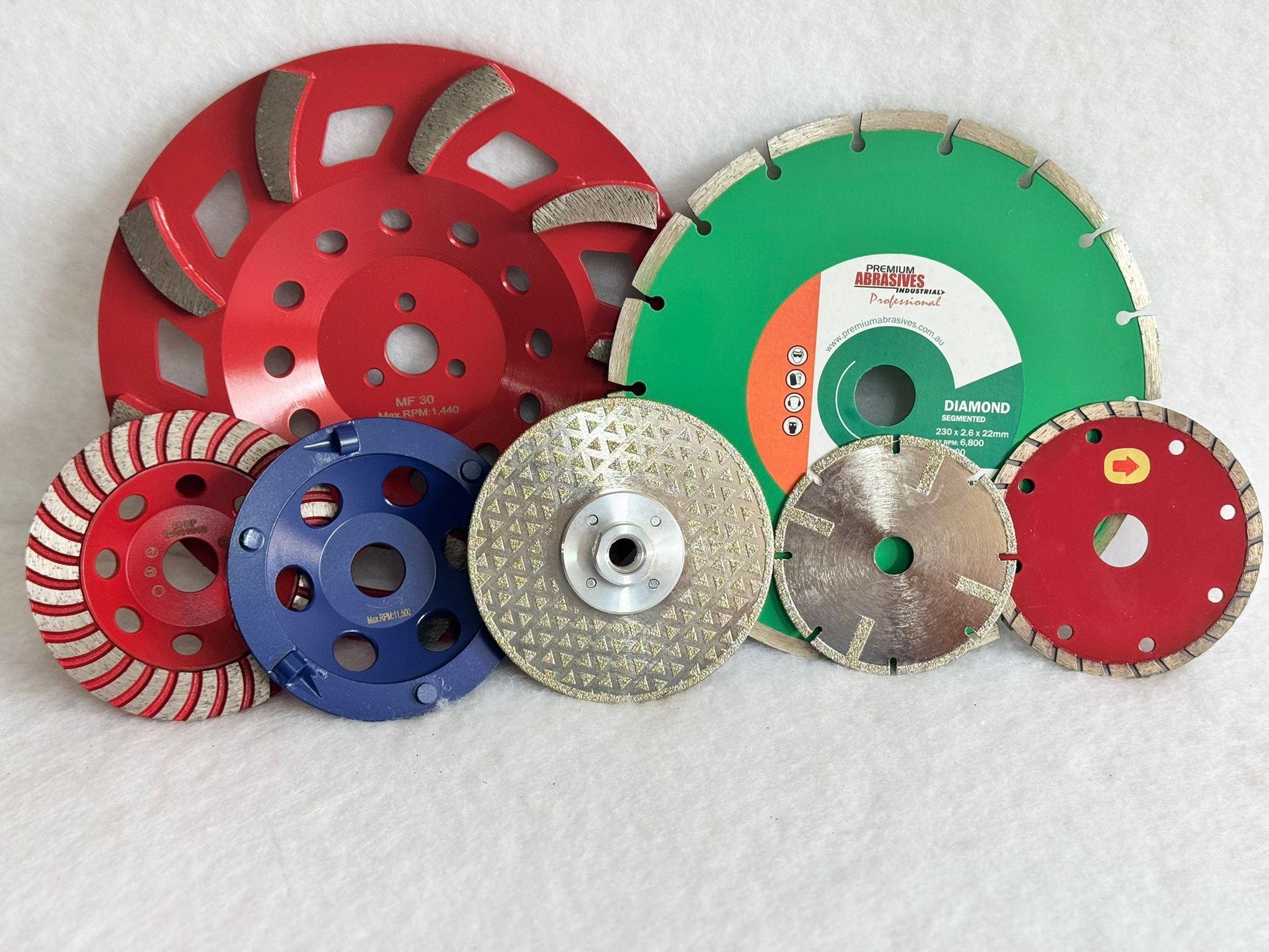 A pair of saw blades sitting on top of each other on a blue surface.