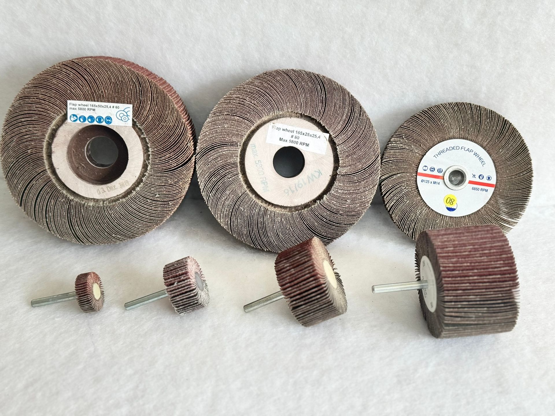 A bunch of brushes are sitting on top of each other on a yellow surface.