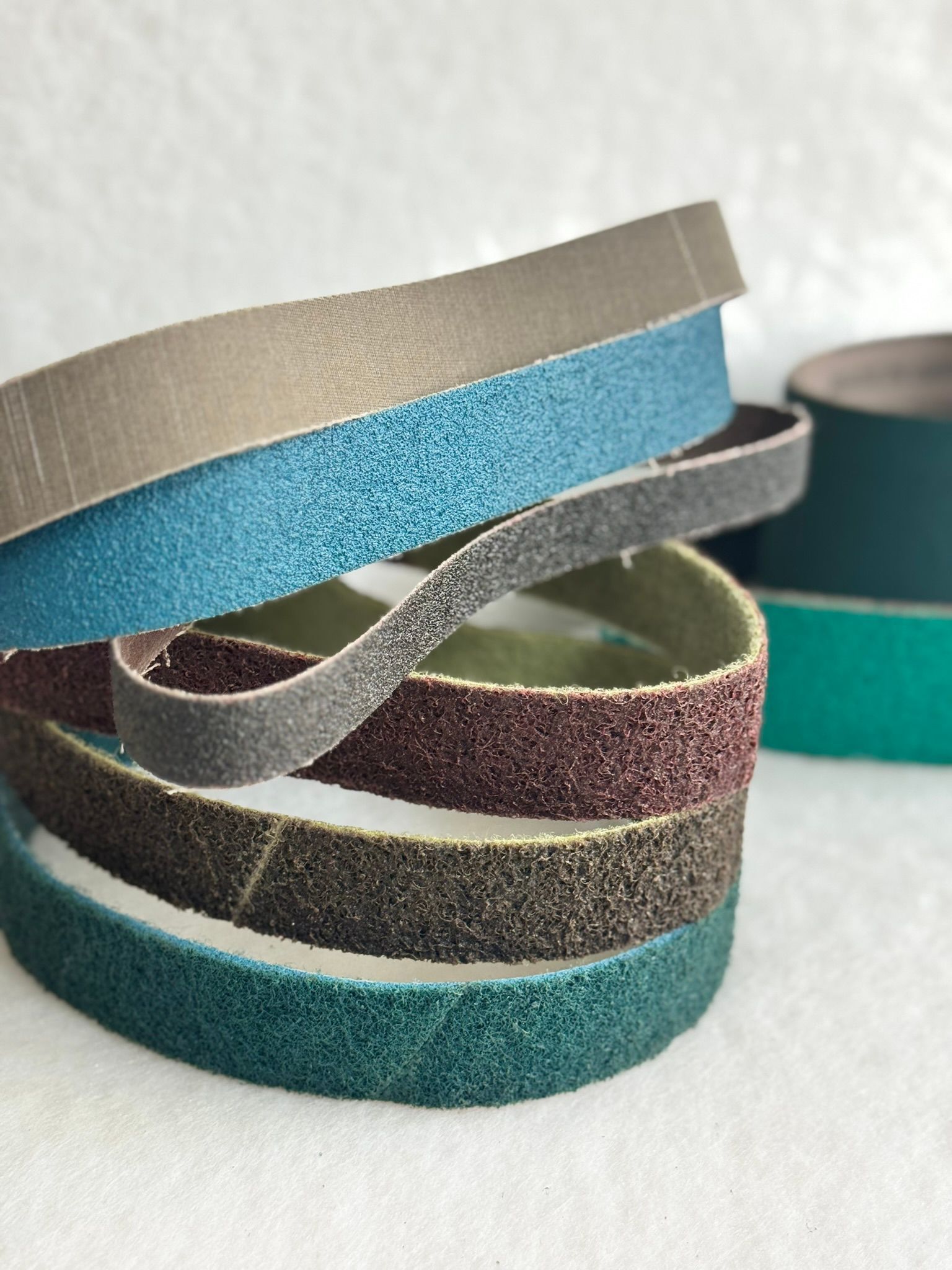 A bunch of different types of tape are sitting on top of each other on a table.