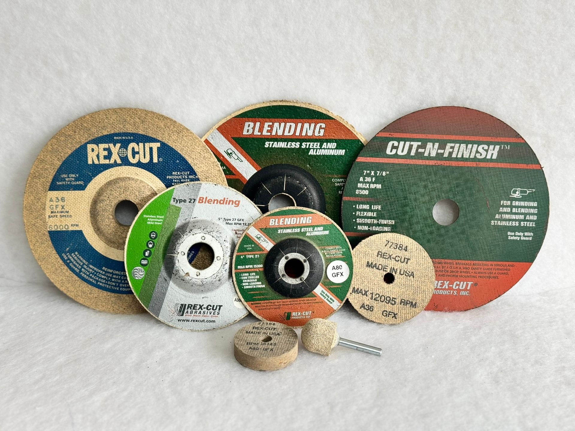 A bunch of different types of polishing wheels are sitting on top of each other on a table.