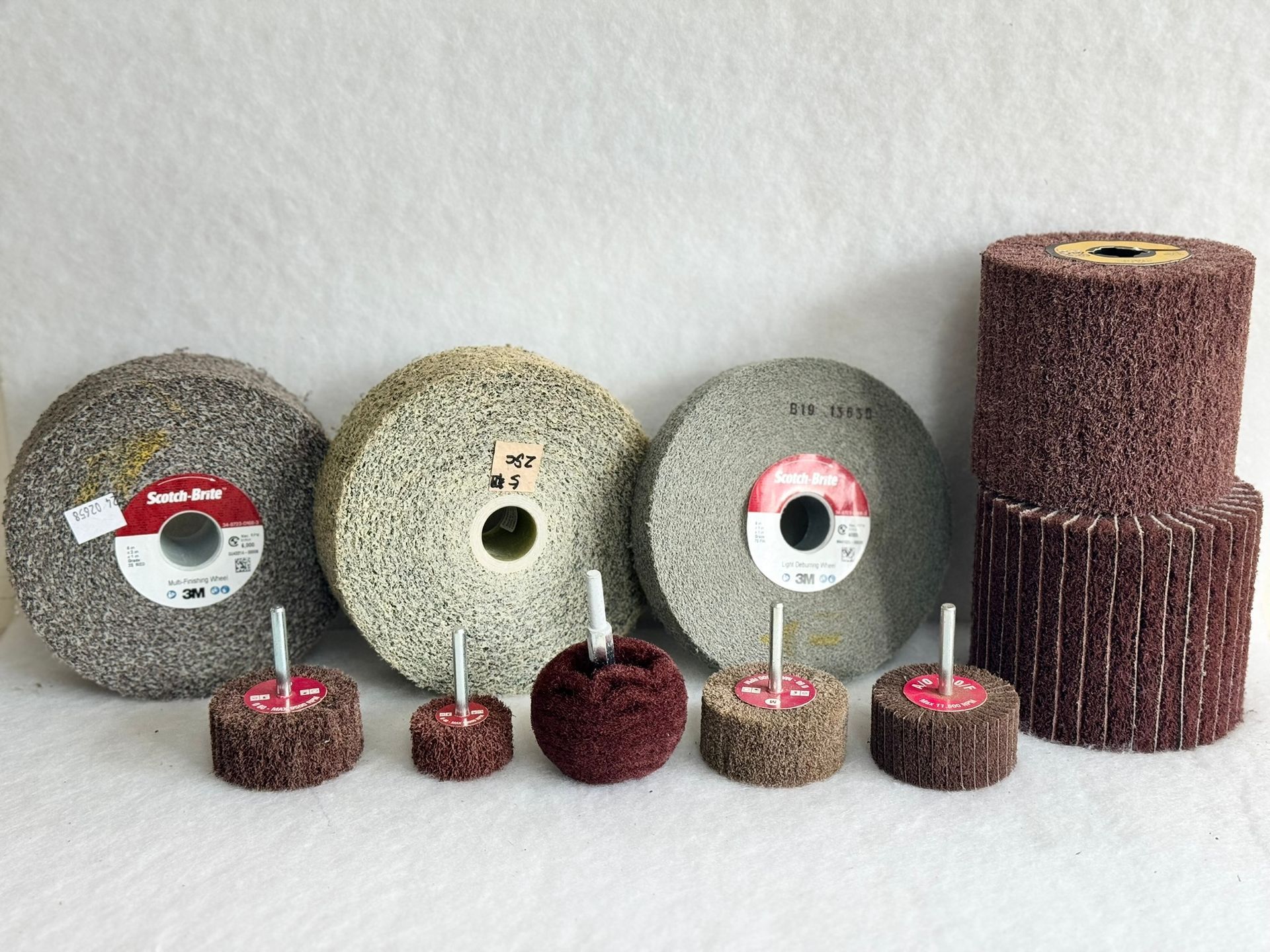 Three different types of brushes are sitting next to each other on a white surface.