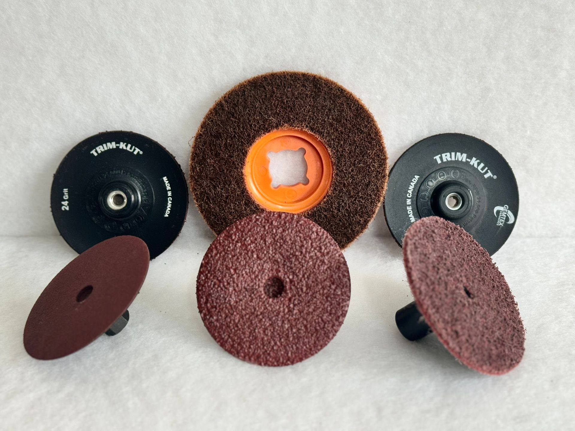 Three different colored sponges are sitting on top of each other on a white surface.