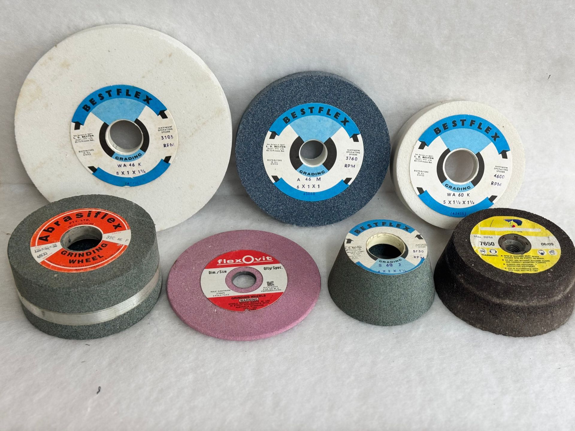 A bunch of different types of polishing wheels are sitting on top of each other on a table.