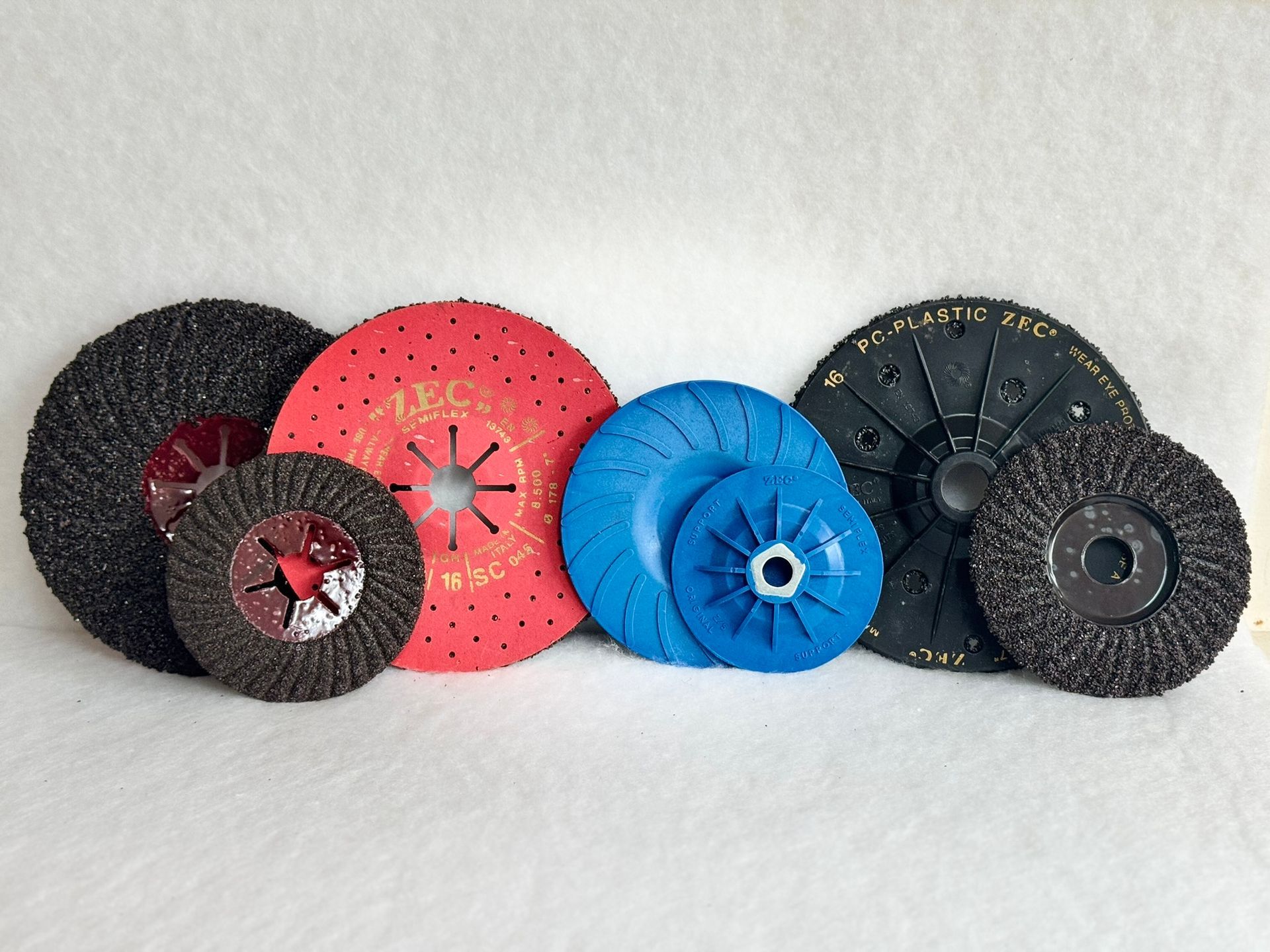 Two grinding wheels are stacked on top of each other in front of a fire.