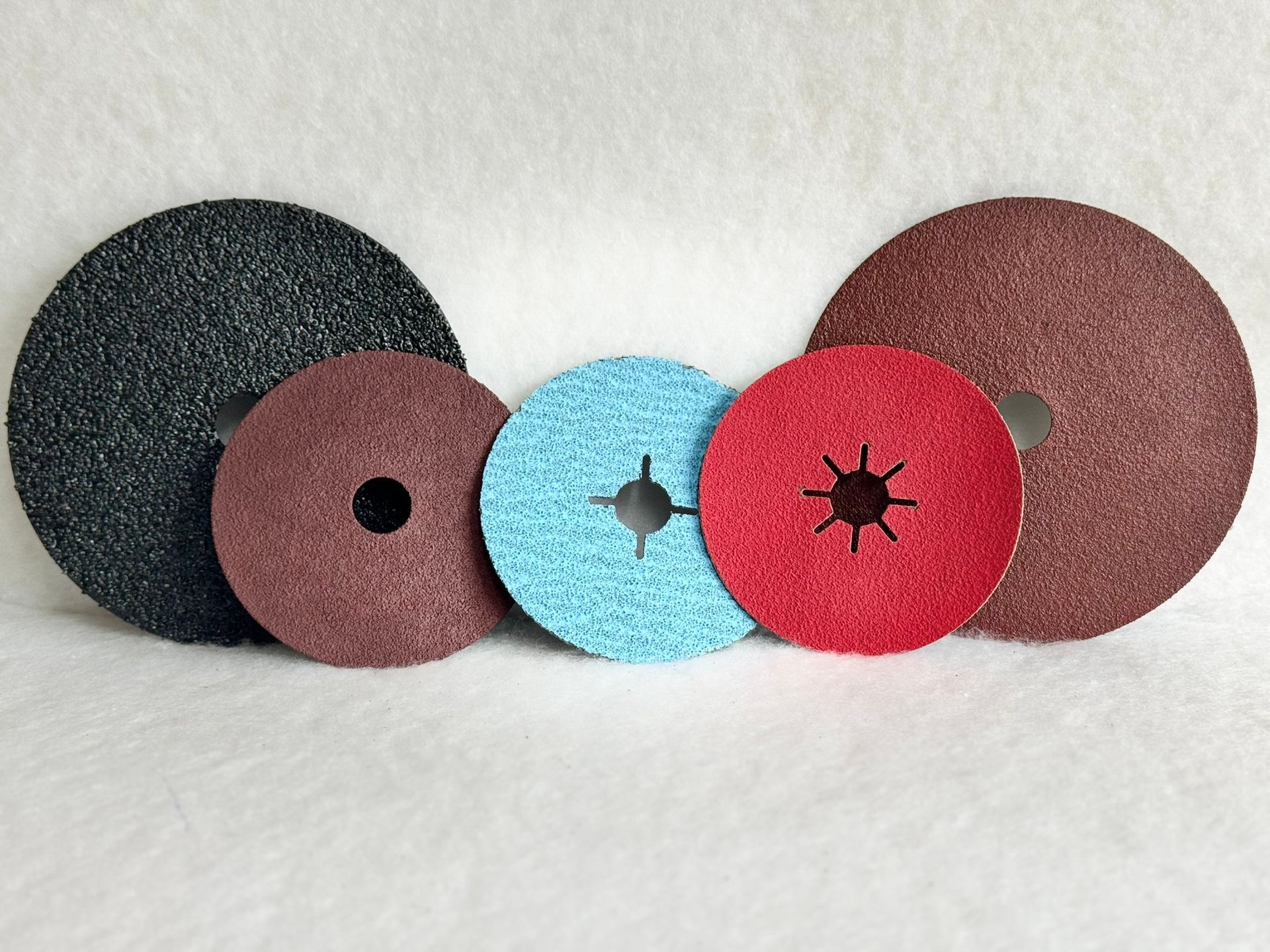 Three different colored pads are sitting on top of each other on a white surface.