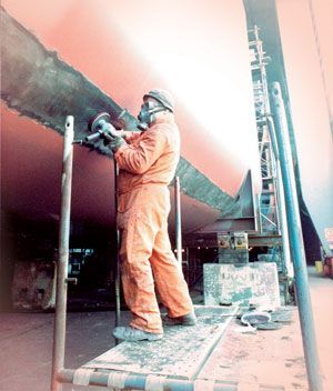 A man wearing a gas mask is standing on a scaffolding A man wearing a gas mask is standing on a scaffolding