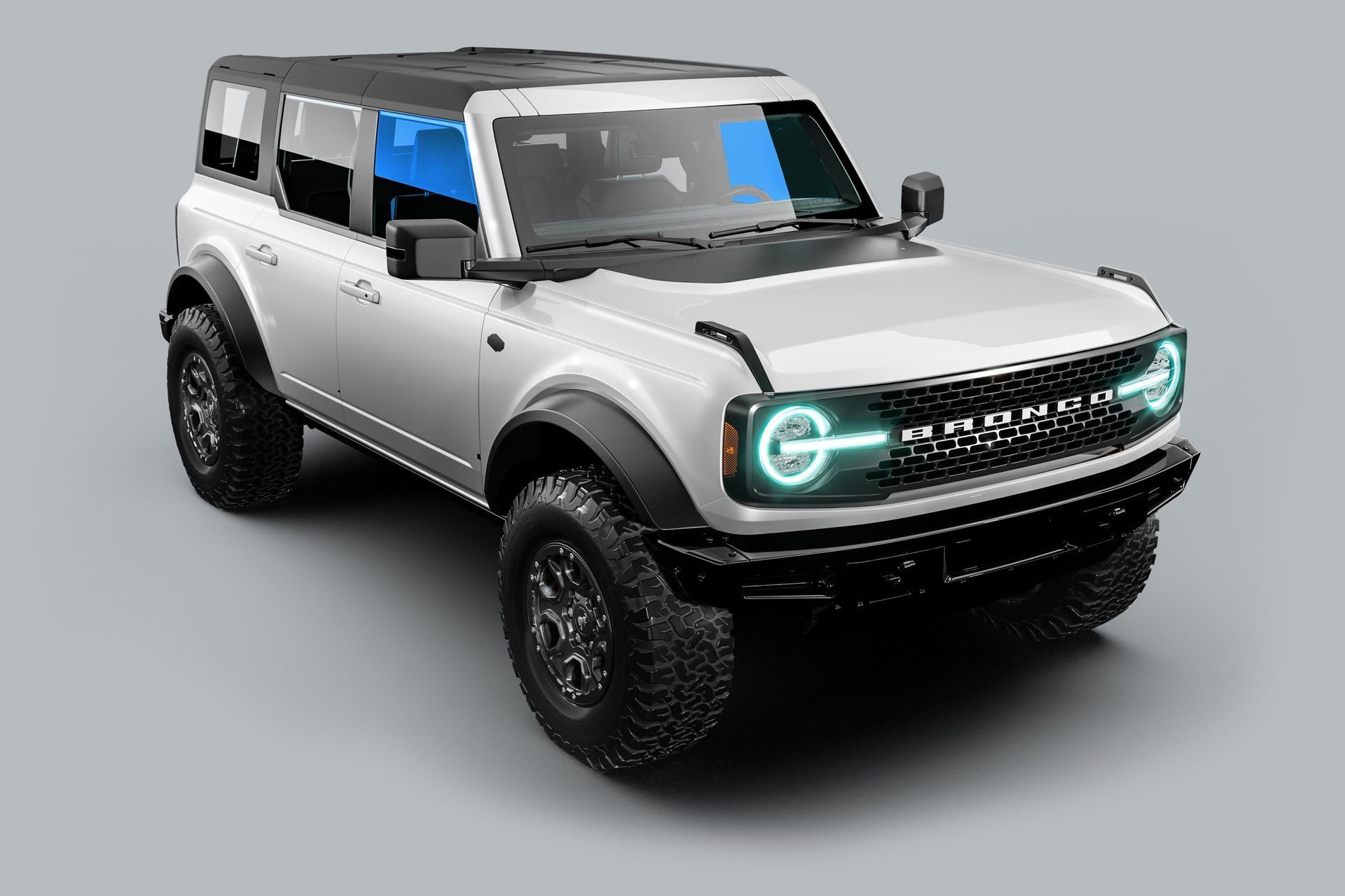A white ford bronco is sitting on a gray surface.