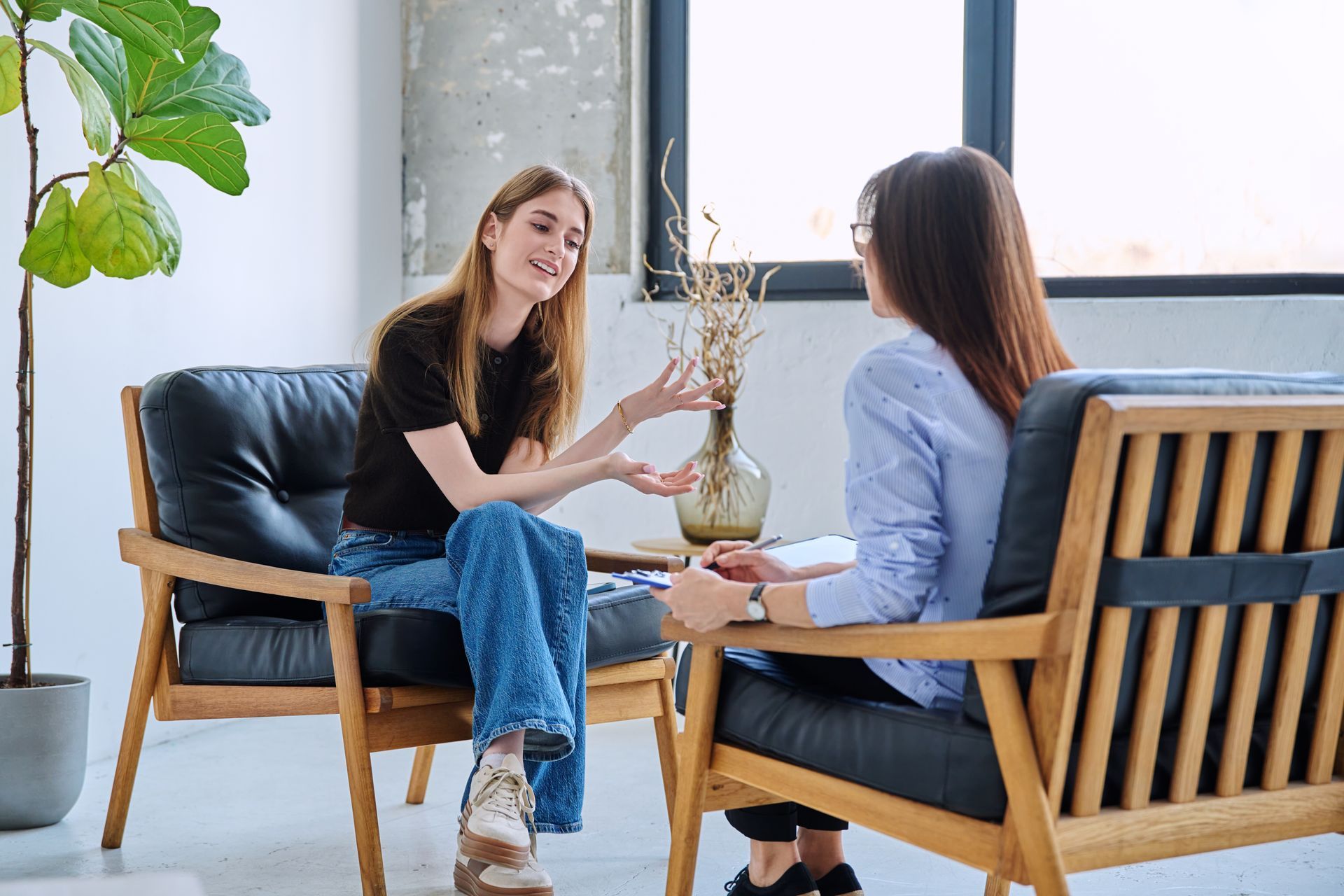 Woman in therapy, talking to her therapist in a modern office.