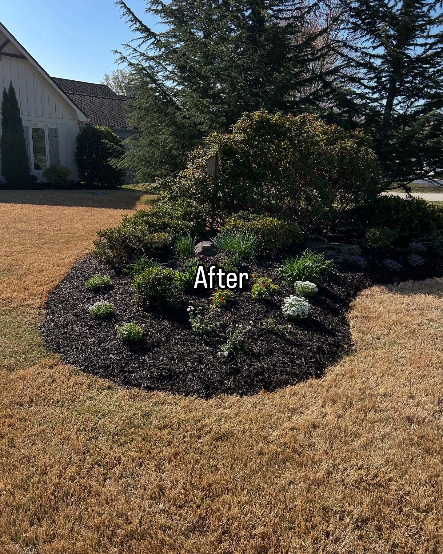 Curving concrete walkway leading to a house with a white porch. Green grass on either side.