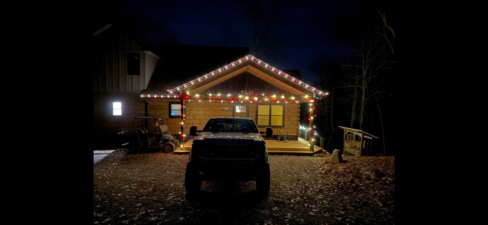 Person in lift basket installing gutter on a beige house, blue sky background.