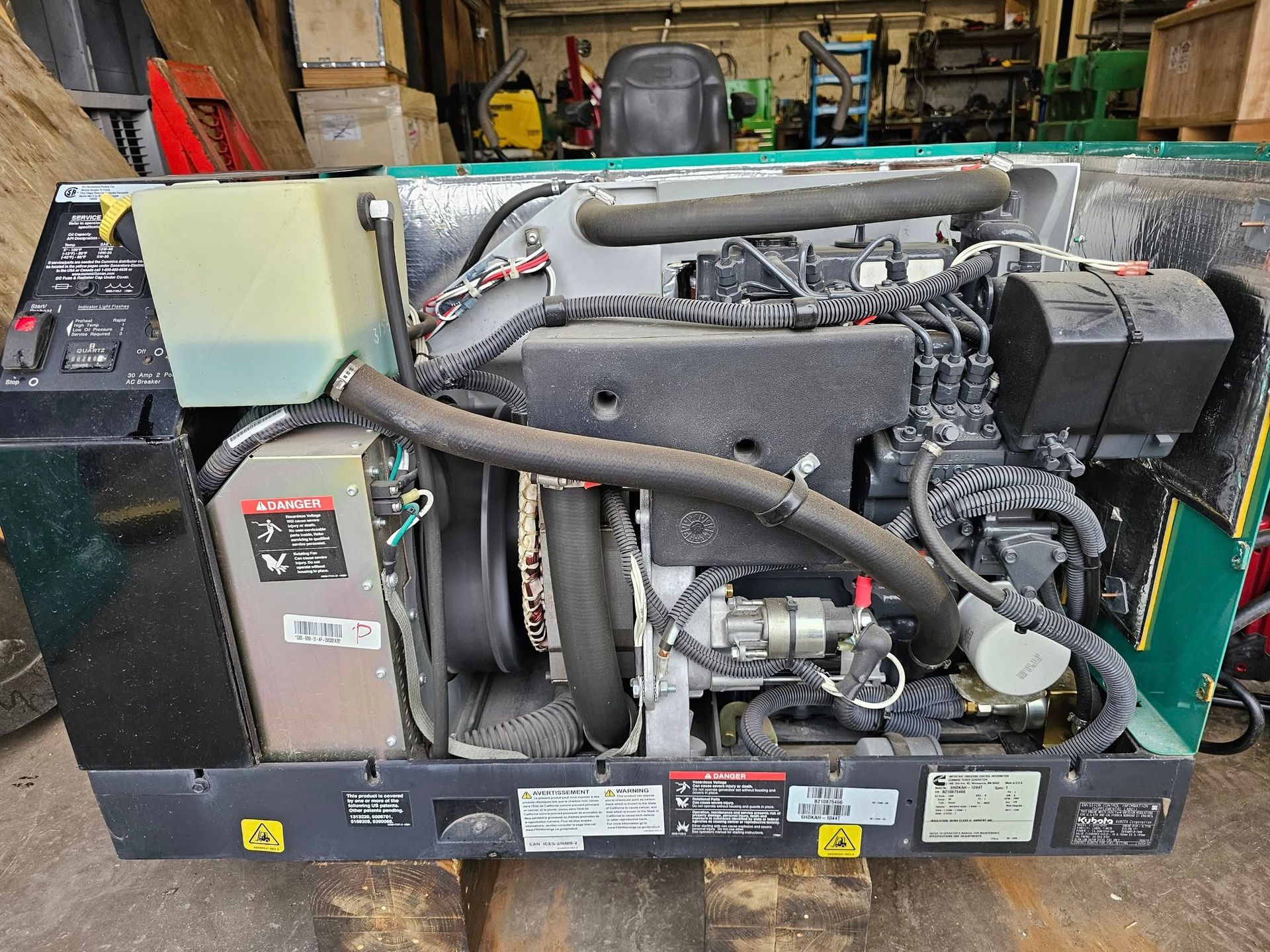 A diesel engine is sitting on a wooden pallet in a garage.