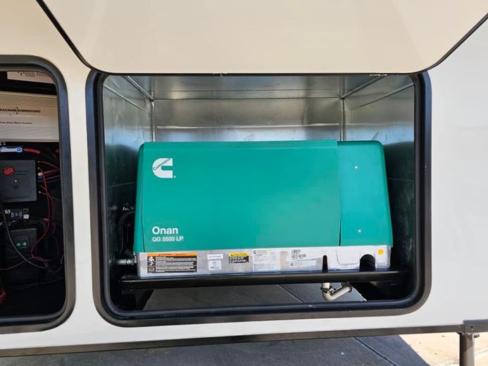 A green generator is sitting inside of a trailer.