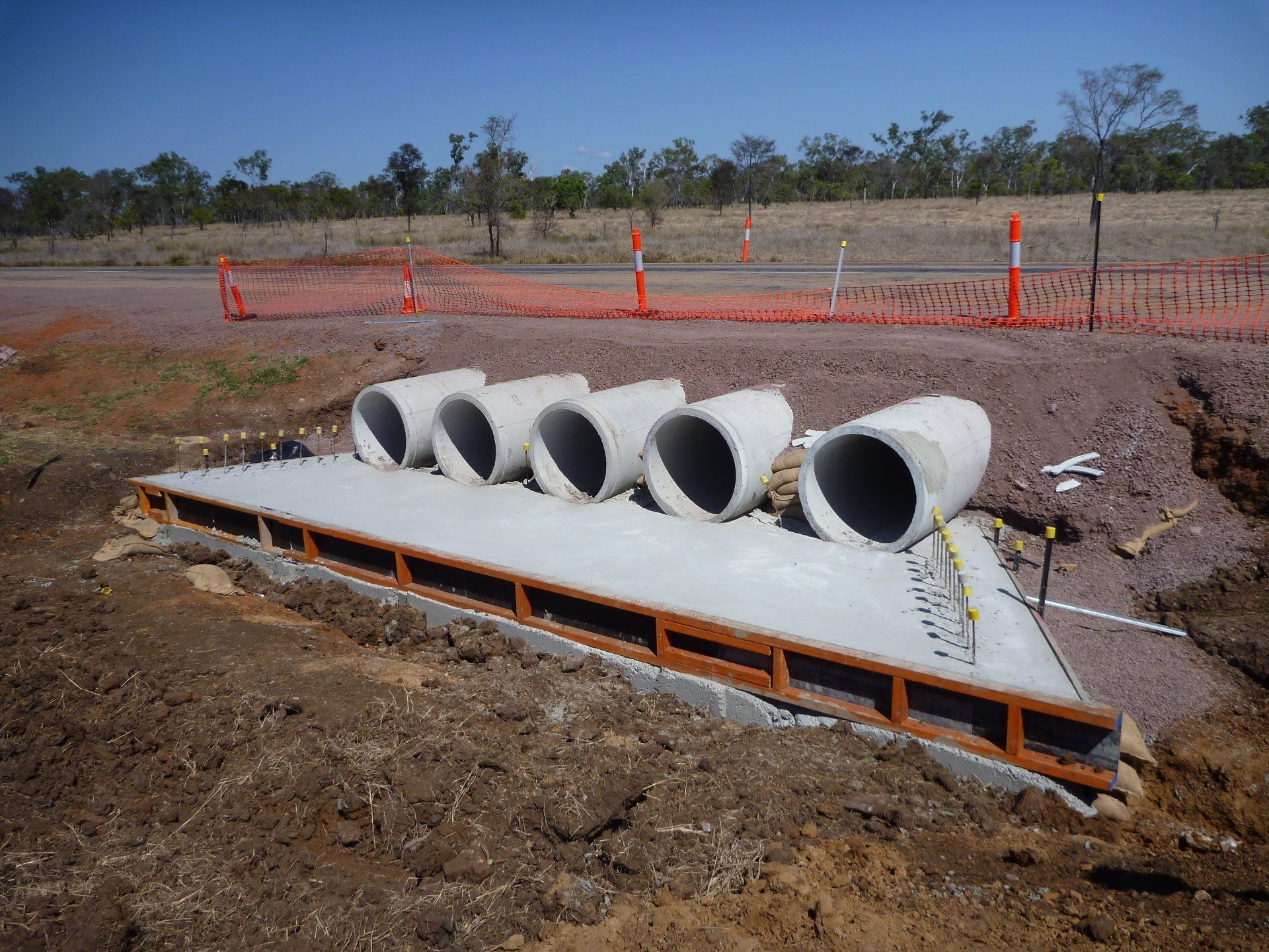 Concrete Sewer Pipe Sections Lined Up on the Grass — Whitsunday Drainage Contractors in Airlie Beach, QLD