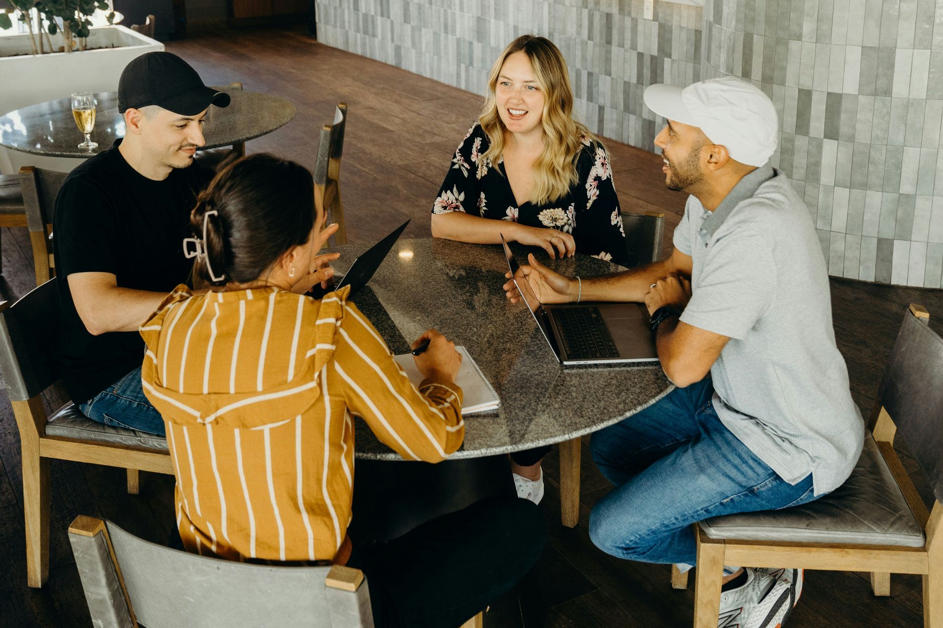 A group of people are sitting around a table having a conversation.