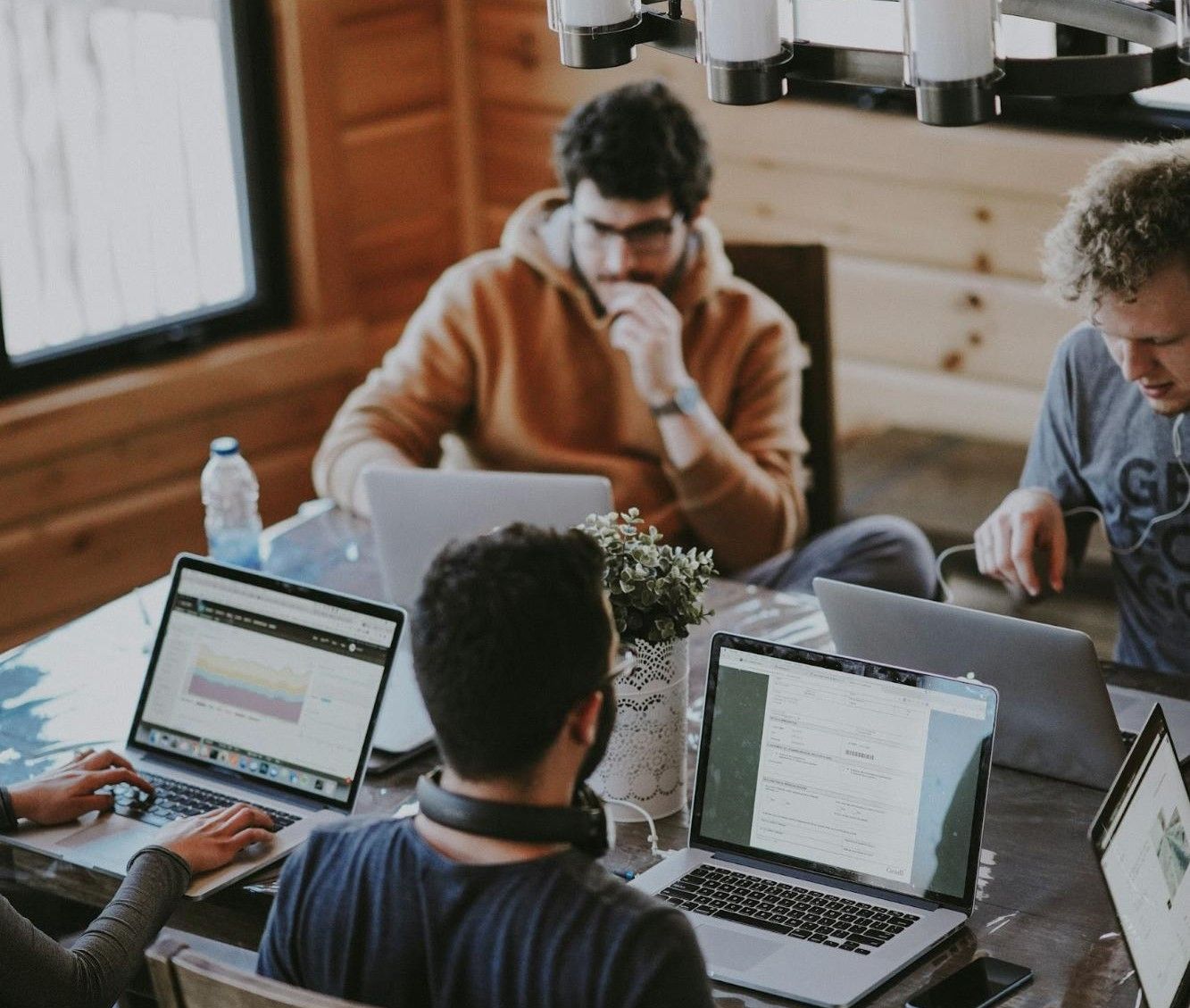 In-house marketing team working together in modern office environment with computers and marketing charts