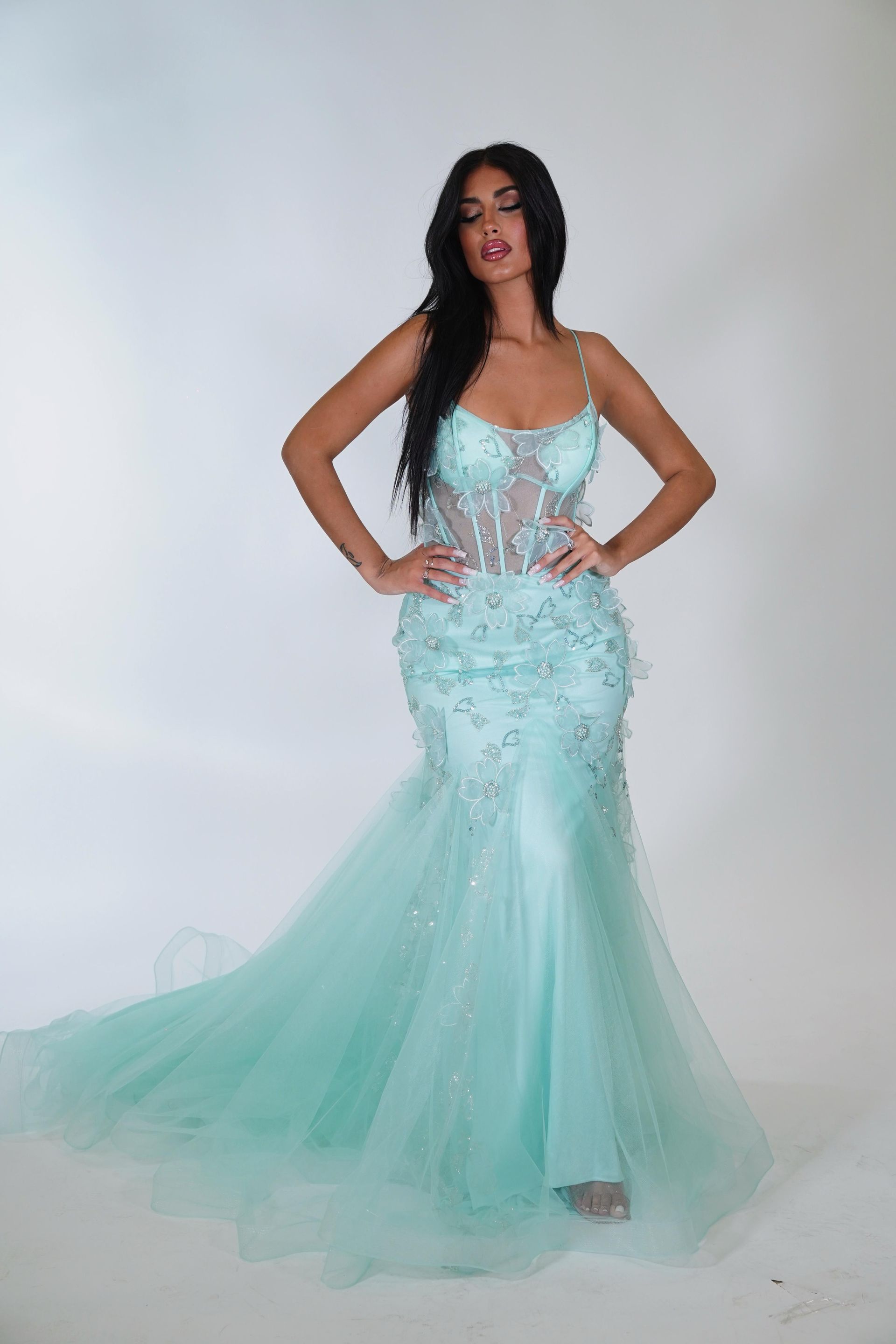 Una donna è in piedi con un lungo abito verde menta.