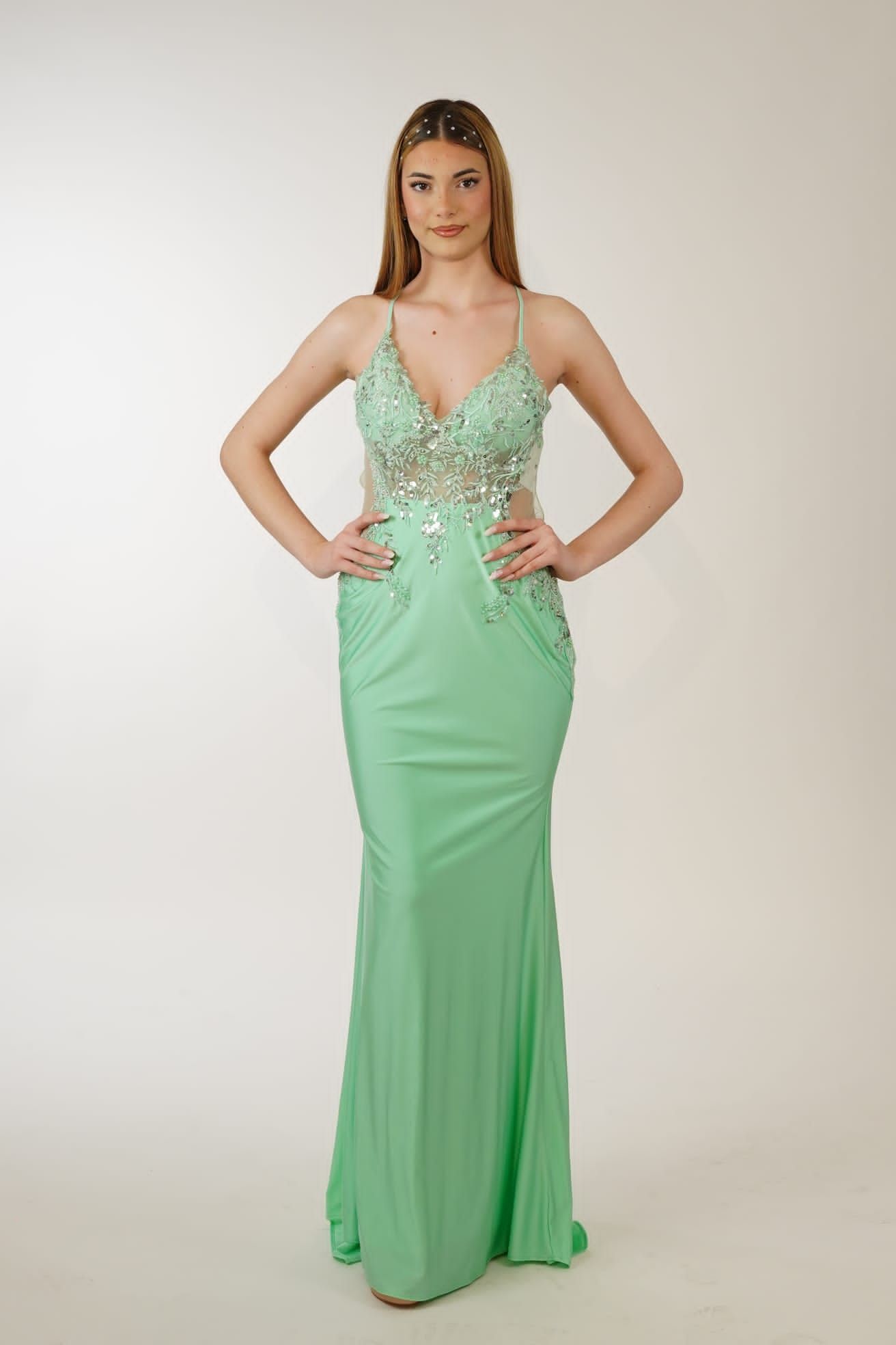 Una donna indossa un lungo abito verde con una profonda scollatura.