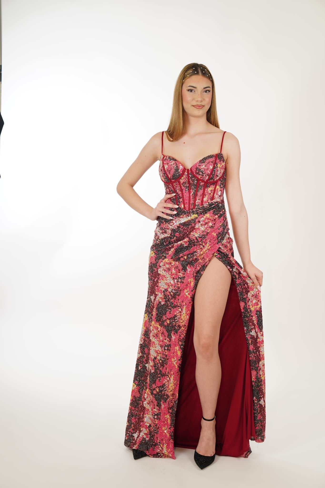 Una donna indossa un lungo abito rosso con uno spacco profondo.