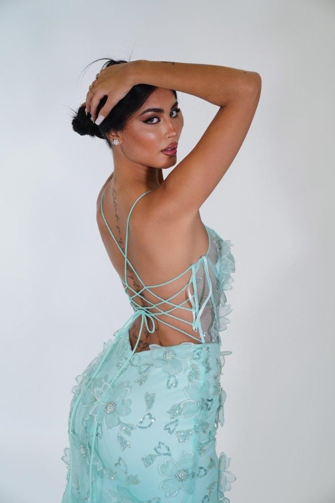 Una donna indossa un vestito verde menta con la schiena allacciata.