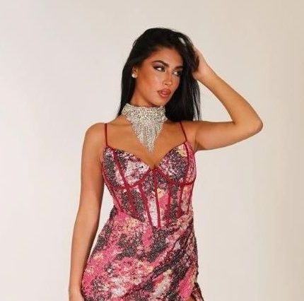 Una donna con un vestito rosa e un girocollo al collo