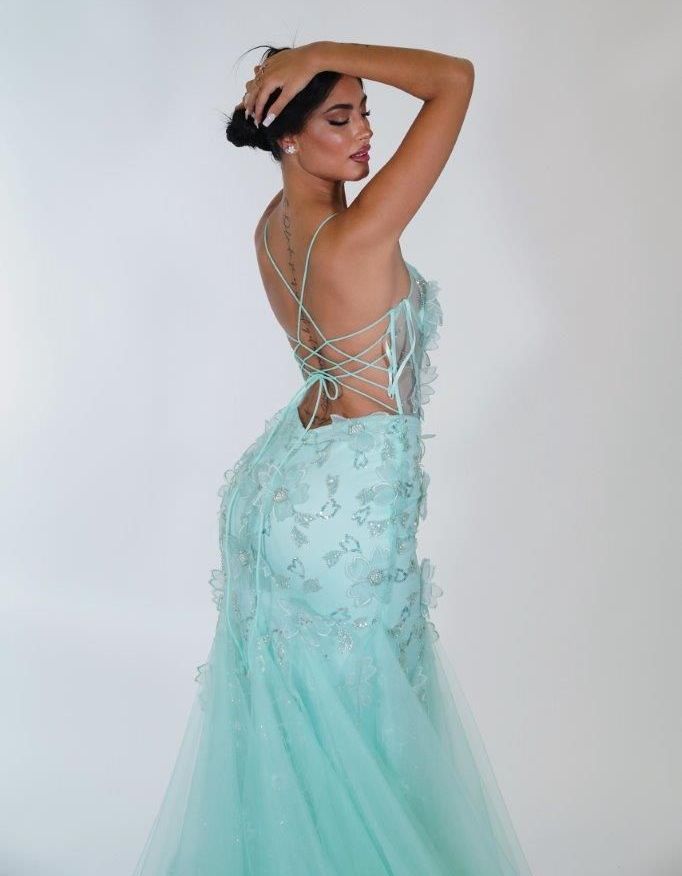 Una donna indossa un vestito verde menta con la schiena allacciata.