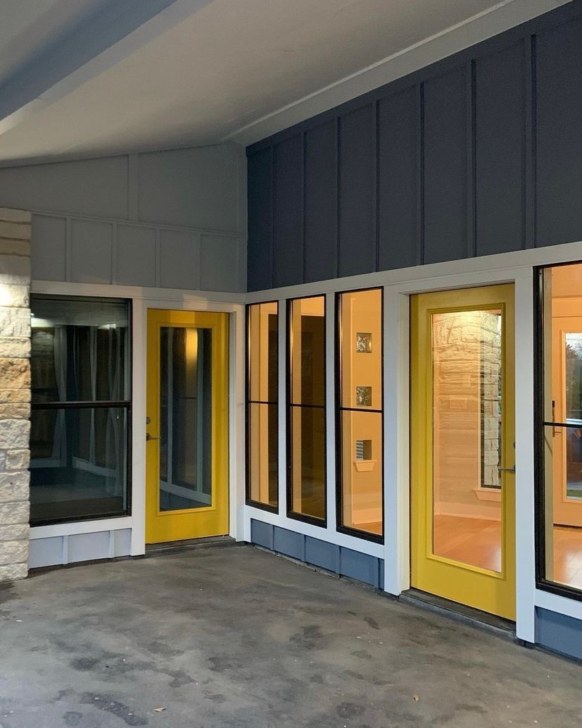 Covered walkway with yellow-framed storefront windows and doors on a gray concrete floor