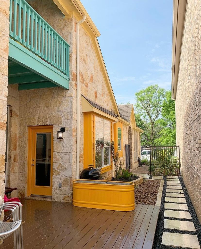 A house with a yellow door and a green balcony