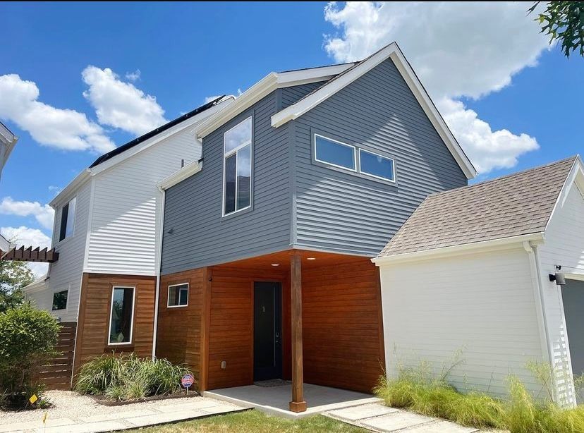 A house with a lot of windows and a blue sky in the background