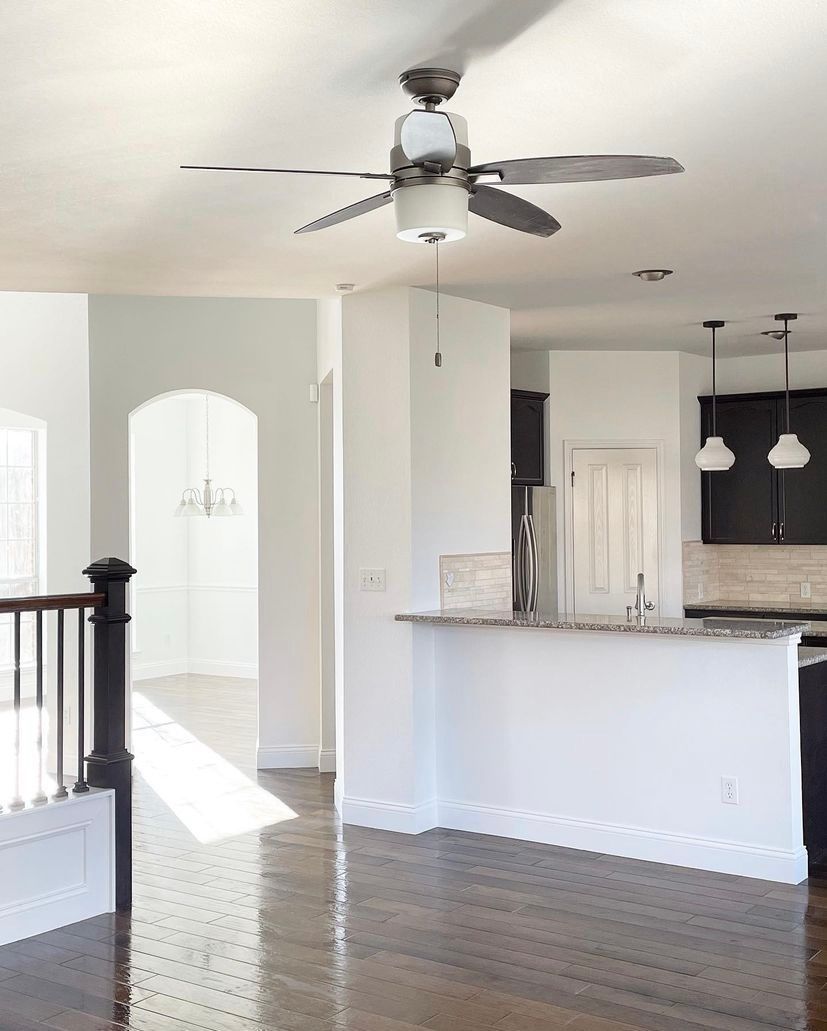 An empty kitchen with a ceiling fan hanging from the ceiling