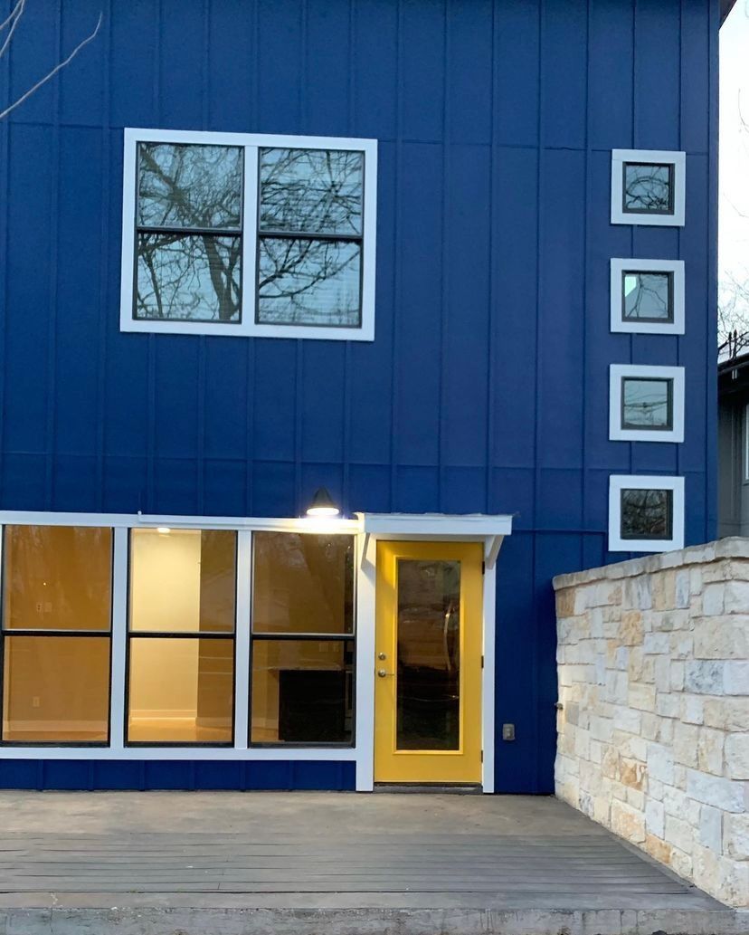A blue building with a yellow door and windows