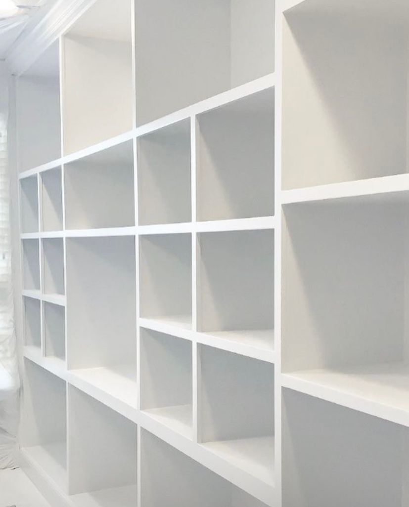 A row of empty white shelves in a room.