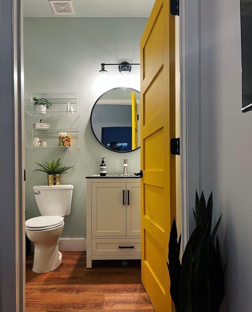 A bathroom with a yellow door and a toilet