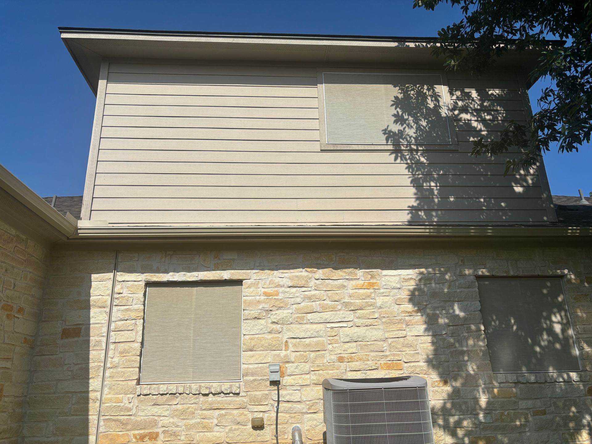 The back of a house with a window boarded up