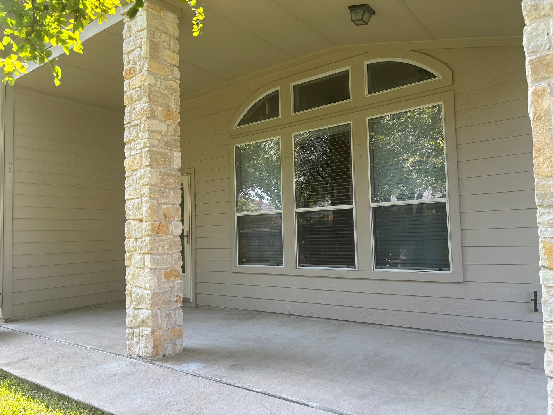 An empty porch of a house with a large window