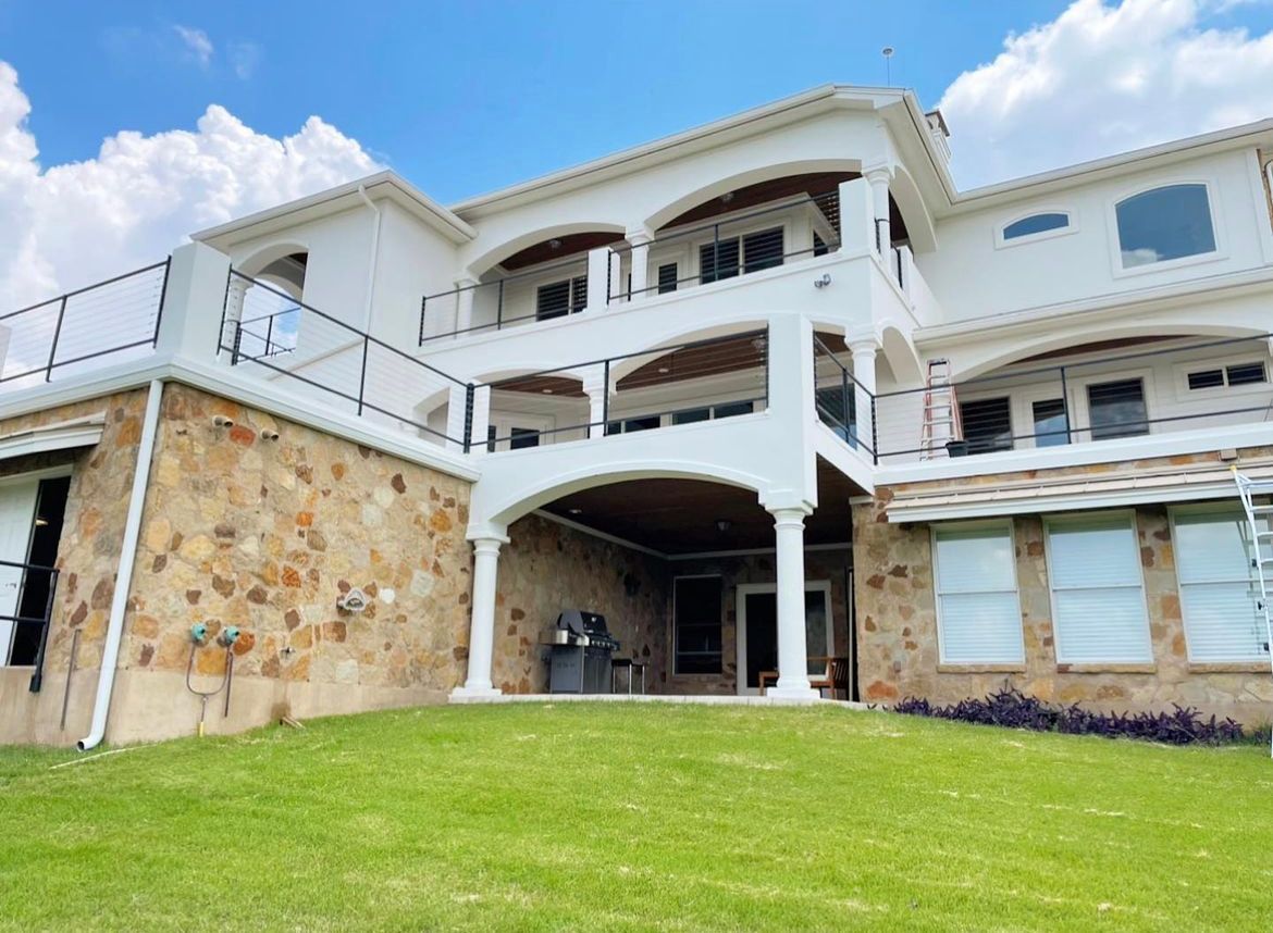 A large white house with a large lawn in front of it.